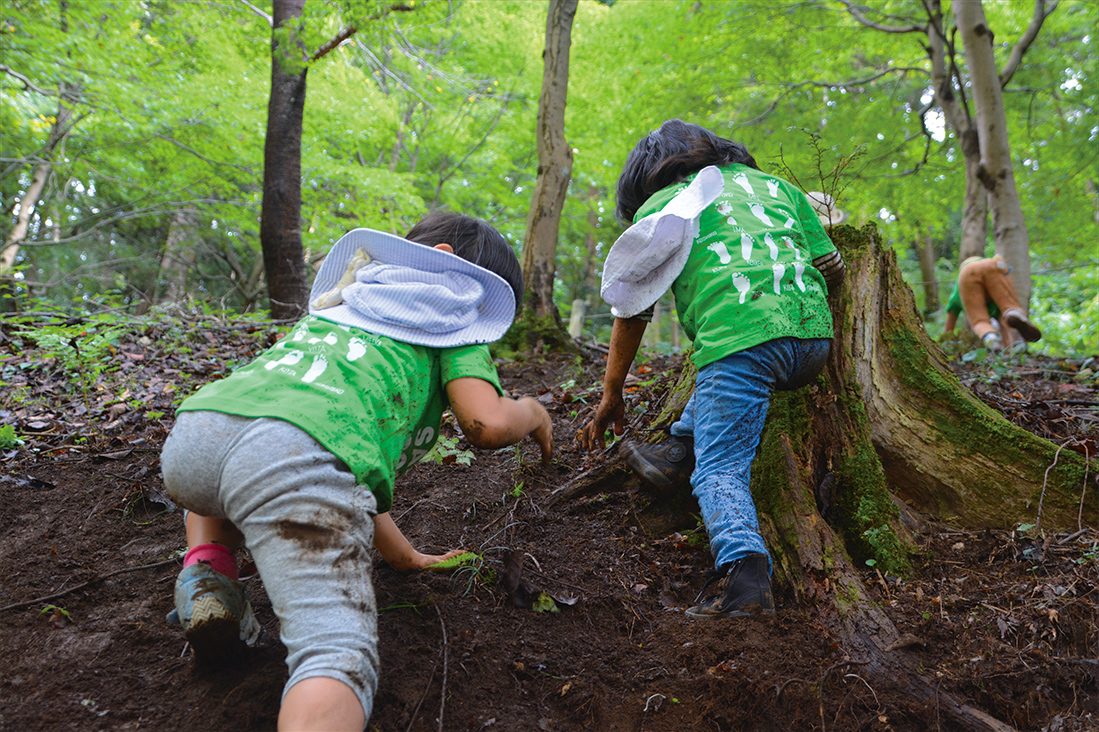 子ども2人が森で遊ぶ様子