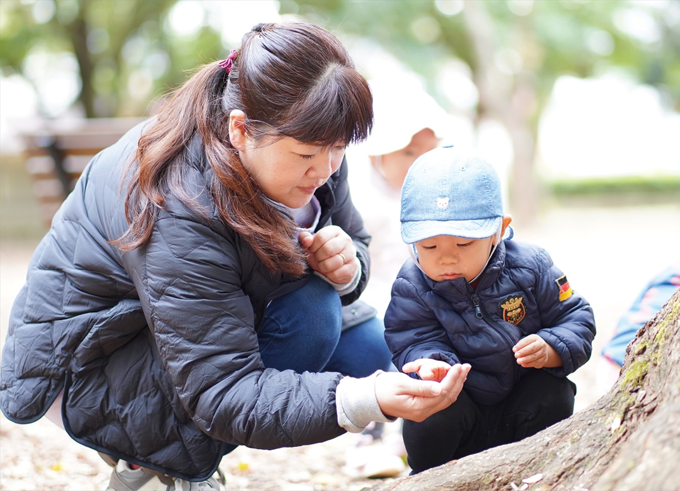 保育士と園児の2人が何かを手にとって観察する様子
